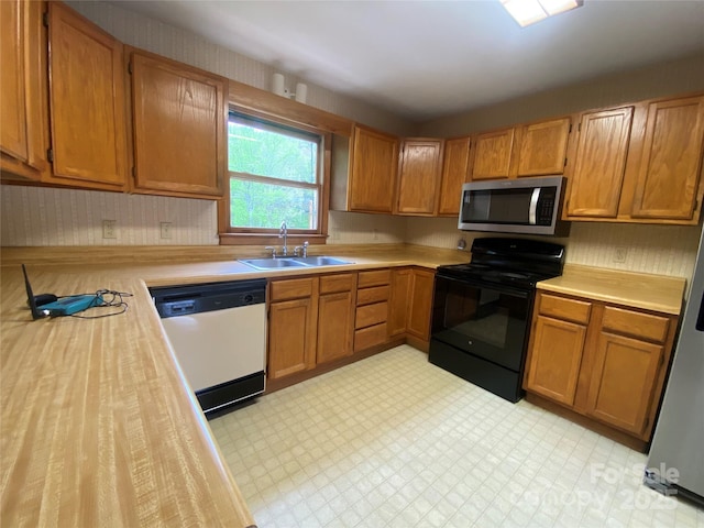 kitchen with light countertops, a sink, stainless steel microwave, white dishwasher, and black electric range