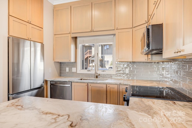 kitchen featuring backsplash, light stone counters, stainless steel appliances, and a sink