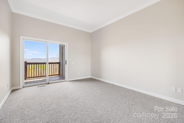 carpeted spare room with visible vents, baseboards, and ornamental molding