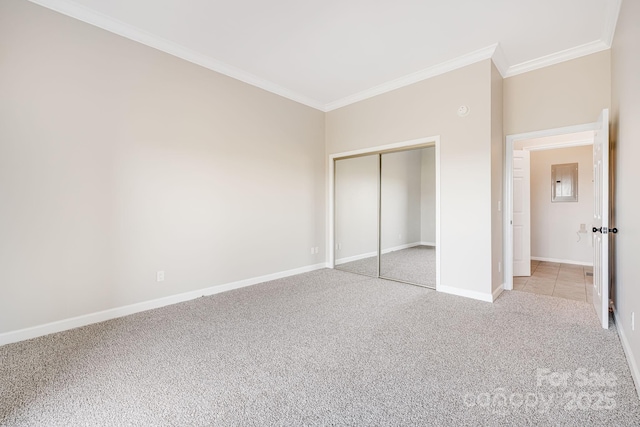 unfurnished bedroom featuring light carpet, baseboards, a closet, and ornamental molding