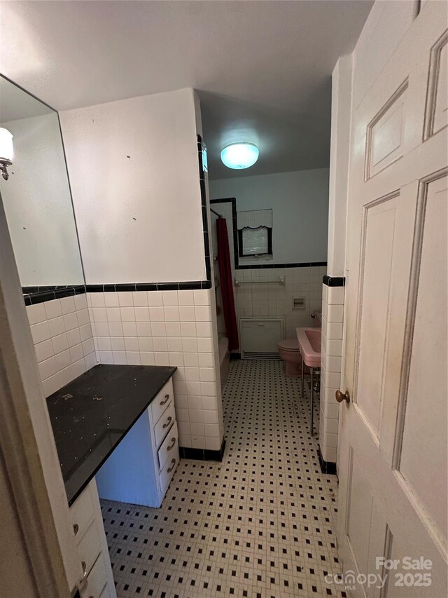 404 S Mulberry St, Cherryville, NC 28021 - bathroom featuring tile patterned floors, wainscoting, tile walls, toilet, and a shower with shower curtain