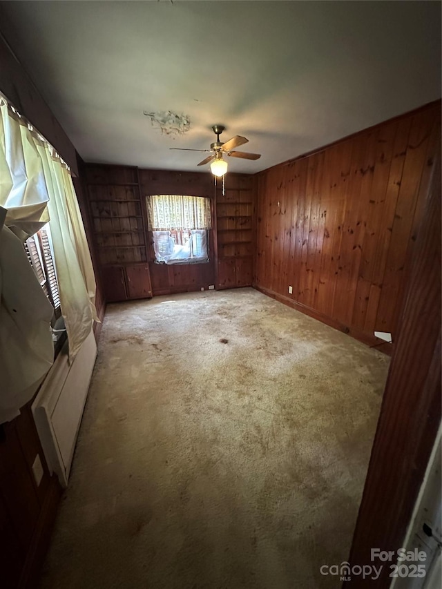 404 S Mulberry St, Cherryville, NC 28021 - spare room with wooden walls, carpet, and ceiling fan