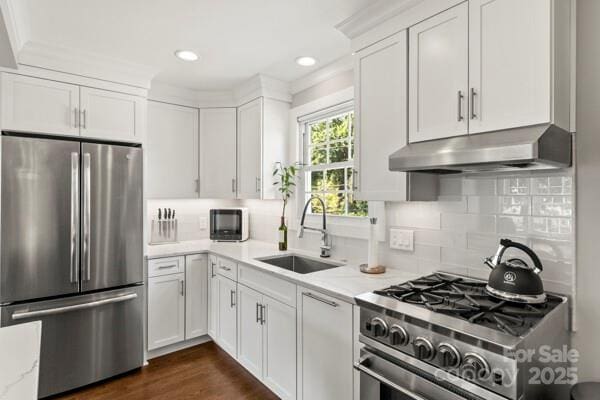 241 Wakefield Dr Unit C, Charlotte, NC 28209 - kitchen featuring a sink, appliances with stainless steel finishes, white cabinets, backsplash, and under cabinet range hood