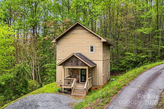 chalet / cabin with a porch and a wooded view