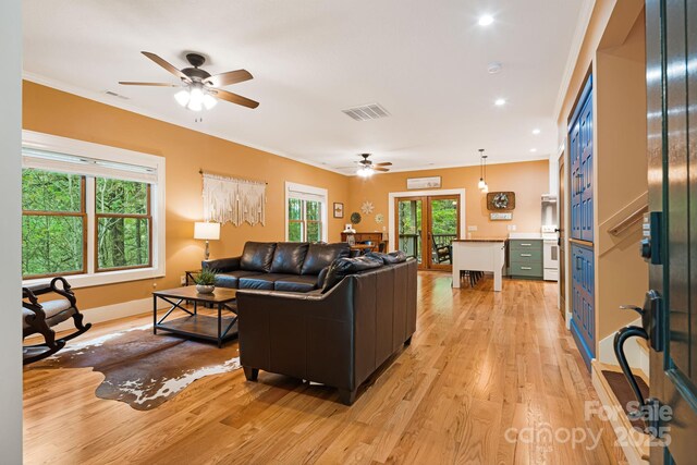 living area with a ceiling fan, visible vents, and light wood-style floors