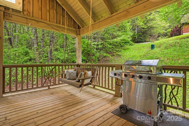 deck with area for grilling and a wooded view