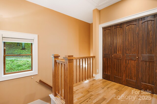 interior space with wood finished floors, vaulted ceiling, and an upstairs landing