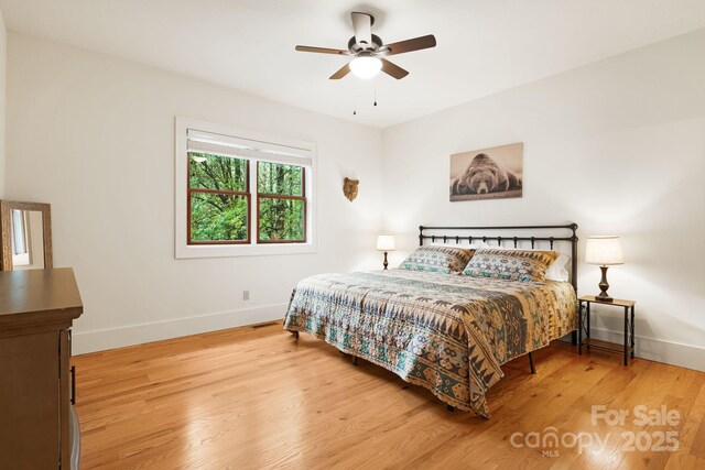 bedroom with baseboards, light wood-style floors, and ceiling fan