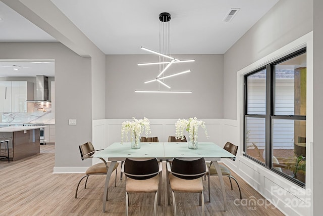 127 Holt Ln, Mooresville, NC 28117 - dining room with a decorative wall, visible vents, wainscoting, and light wood-type flooring