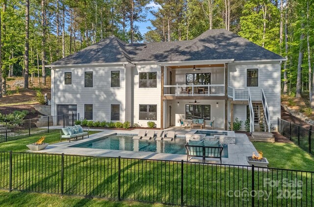 127 Holt Ln, Mooresville, NC 28117 - rear view of house with an outdoor living space with a fire pit, ceiling fan, a balcony, a fenced backyard, and a lawn