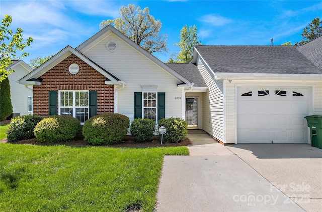 single story home featuring a garage, concrete driveway, a shingled roof, a front yard, and brick siding