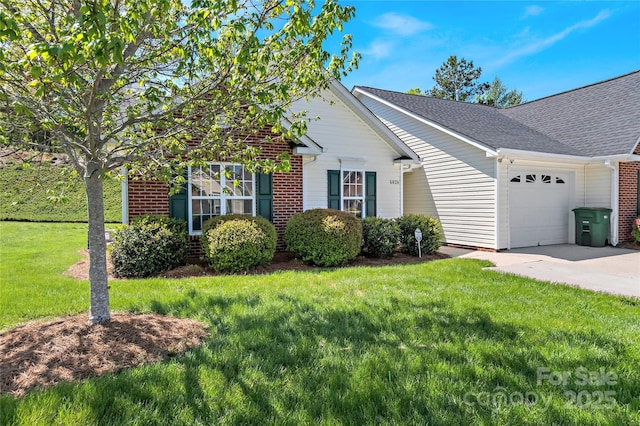 ranch-style home featuring a front lawn, roof with shingles, concrete driveway, an attached garage, and brick siding