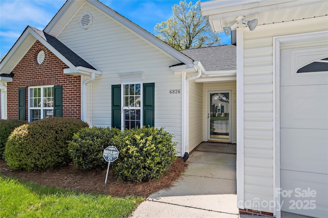 entrance to property with a shingled roof