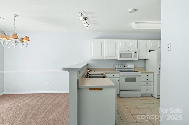 kitchen with white cabinets, an inviting chandelier, light countertops, a sink, and white appliances