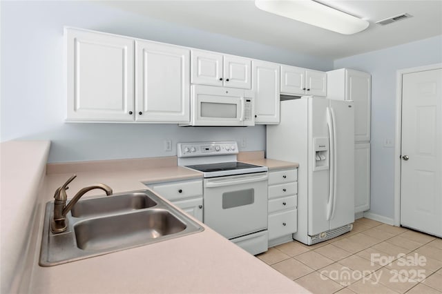 kitchen with visible vents, white appliances, a sink, and white cabinets