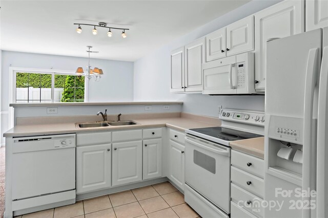kitchen with light countertops, white cabinets, a sink, and white appliances