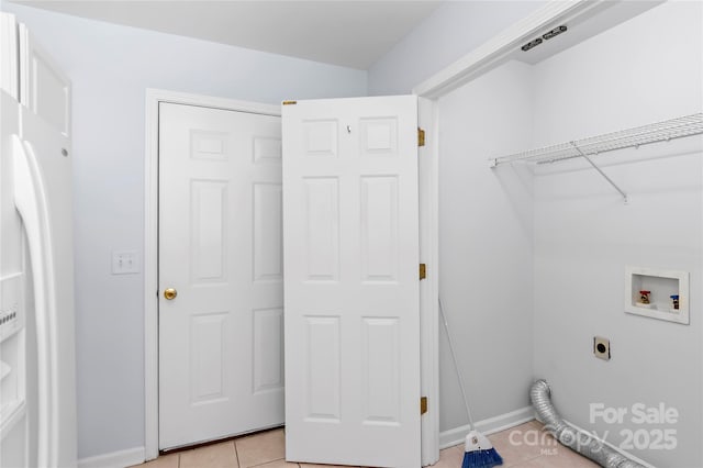 clothes washing area featuring hookup for an electric dryer, baseboards, hookup for a washing machine, laundry area, and light tile patterned floors