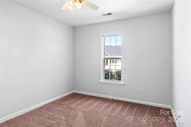 spare room with baseboards, a ceiling fan, visible vents, and carpet