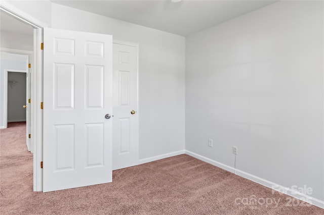 unfurnished bedroom with carpet and baseboards