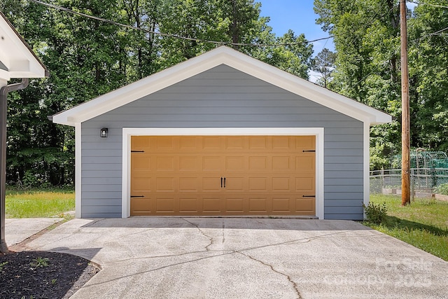 detached garage featuring fence