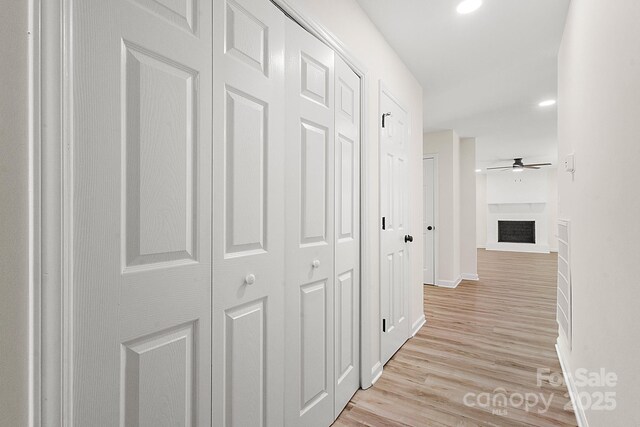 hall with baseboards and light wood finished floors