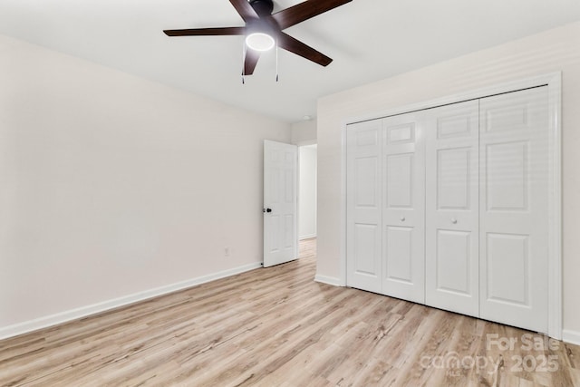 unfurnished bedroom with baseboards, a ceiling fan, wood finished floors, and a closet