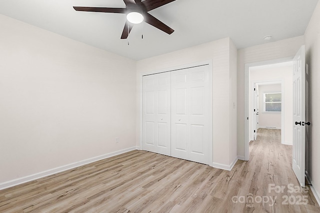 unfurnished bedroom with baseboards, a ceiling fan, a closet, and light wood-style flooring