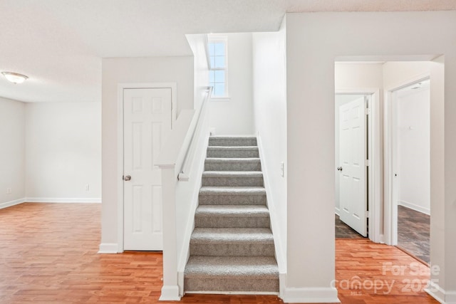 stairway featuring baseboards and wood finished floors