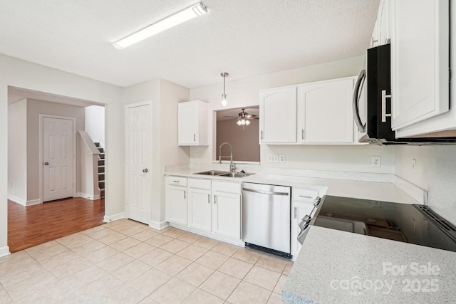 kitchen with light countertops, appliances with stainless steel finishes, white cabinetry, and a sink
