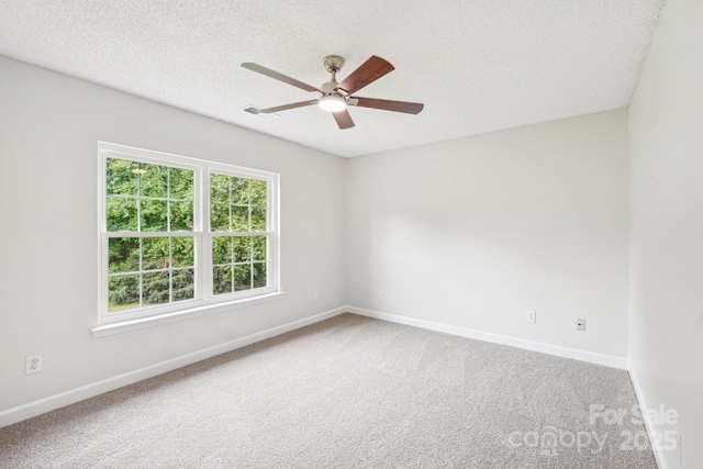 spare room with carpet floors, baseboards, and ceiling fan