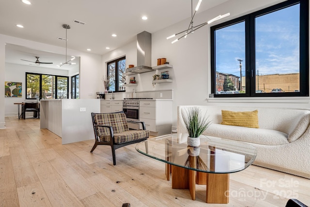 living area with recessed lighting, a ceiling fan, visible vents, and light wood-type flooring