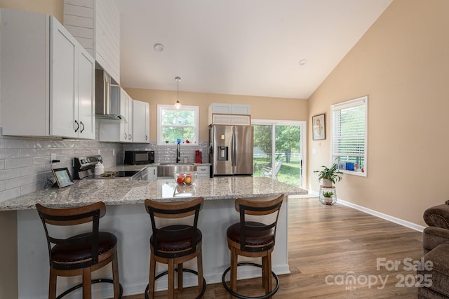 3121 Suffolk Dr, Shelby, NC 28152 - kitchen featuring stainless steel appliances, a peninsula, tasteful backsplash, dark wood-type flooring, and light stone countertops
