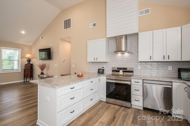 3121 Suffolk Dr, Shelby, NC 28152 - kitchen with wall chimney range hood, stainless steel appliances, a peninsula, high vaulted ceiling, and dark wood-style flooring