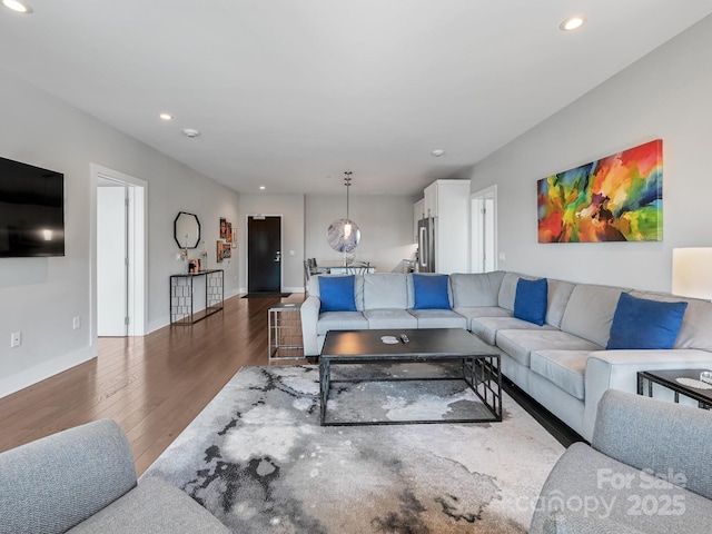 living room featuring recessed lighting, baseboards, and wood finished floors