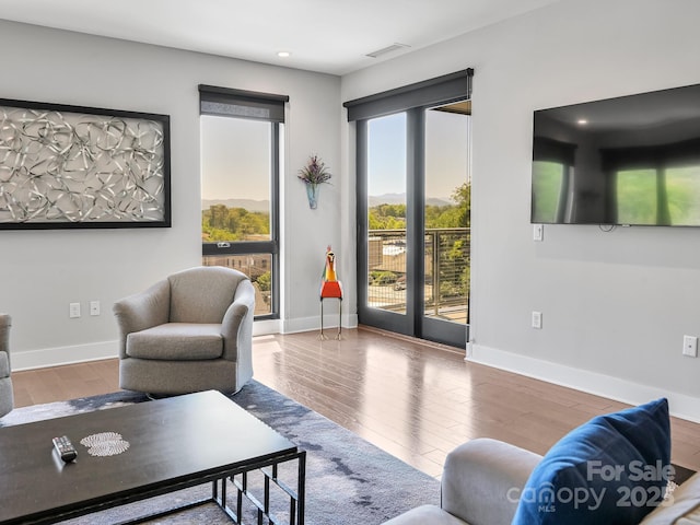 living room featuring baseboards, recessed lighting, wood finished floors, and visible vents