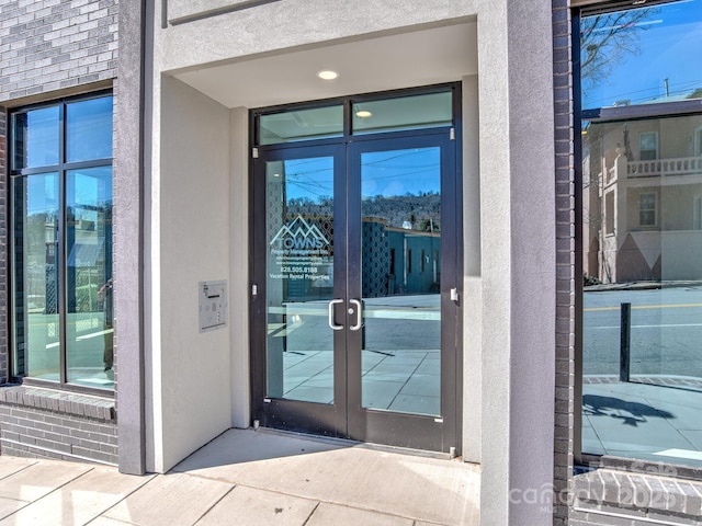 property entrance featuring stucco siding and french doors