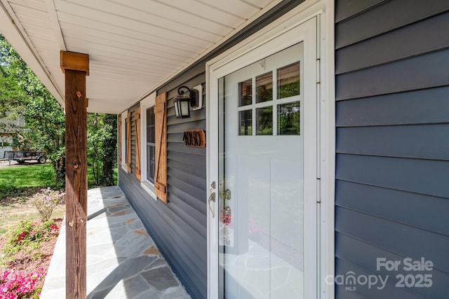 view of exterior entry featuring covered porch