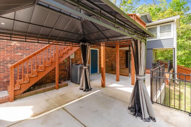 view of patio / terrace featuring fence and stairs