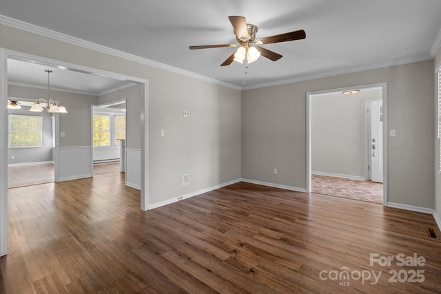 empty room featuring baseboards, ornamental molding, wood finished floors, and ceiling fan with notable chandelier