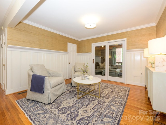 1596 Clayton Dr, Charlotte, NC 28203 - living room with light wood-style floors, a wainscoted wall, crown molding, and a decorative wall