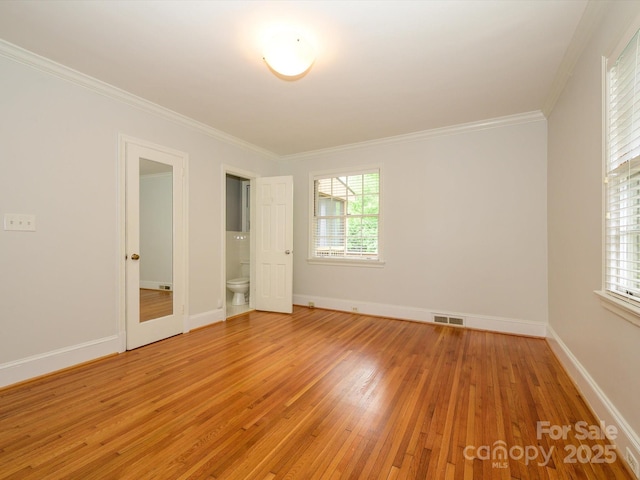 1596 Clayton Dr, Charlotte, NC 28203 - unfurnished bedroom featuring crown molding, visible vents, multiple windows, and light wood finished floors
