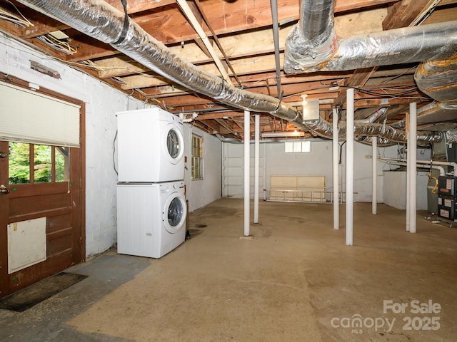 1596 Clayton Dr, Charlotte, NC 28203 - below grade area with stacked washer and clothes dryer, heating unit, and a healthy amount of sunlight