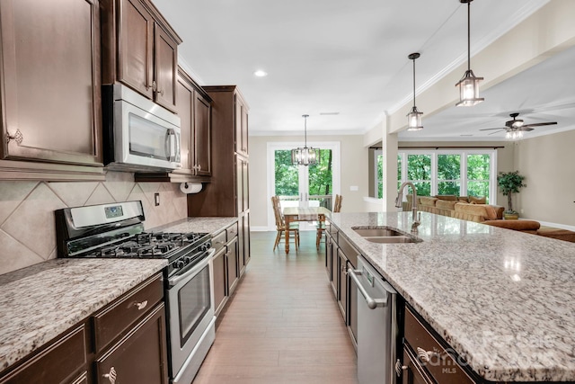 2417 Labelle Dr, Waxhaw, NC 28173 - kitchen featuring appliances with stainless steel finishes, a sink, dark brown cabinetry, decorative backsplash, and open floor plan