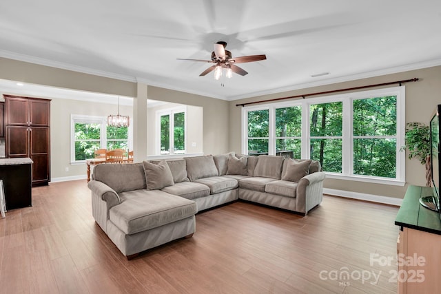 2417 Labelle Dr, Waxhaw, NC 28173 - living room with ceiling fan, baseboards, light wood-style flooring, ornamental molding, and a chandelier