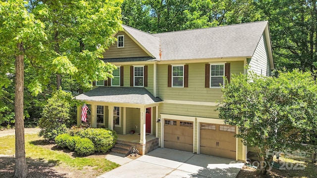 2417 Labelle Dr, Waxhaw, NC 28173 - view of front facade with concrete driveway, a garage, covered porch, roof with shingles, and view of wooded area