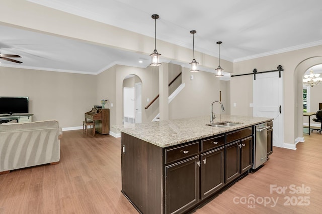2417 Labelle Dr, Waxhaw, NC 28173 - kitchen featuring arched walkways, a barn door, open floor plan, light wood-style floors, and dark brown cabinetry