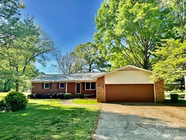 127 Edgeway Rd, Mooresville, NC 28117 - ranch-style home with an attached garage, concrete driveway, a front lawn, and brick siding