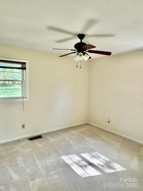 127 Edgeway Rd, Mooresville, NC 28117 - spare room with light carpet, baseboards, a ceiling fan, and a textured ceiling
