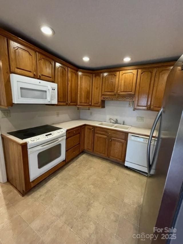 127 Edgeway Rd, Mooresville, NC 28117 - kitchen featuring white appliances, a sink, brown cabinetry, light countertops, and recessed lighting