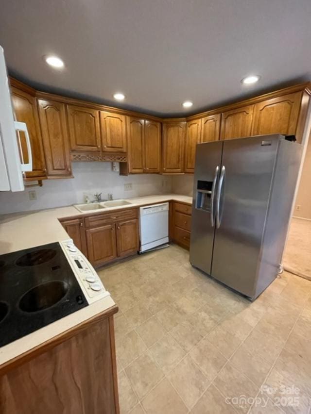127 Edgeway Rd, Mooresville, NC 28117 - kitchen featuring white appliances, a sink, brown cabinetry, light countertops, and recessed lighting
